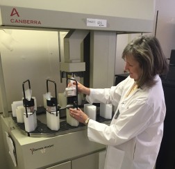 RPB technician, Bonnie Todd, arranging salmon samples on the gamma spectrometer for analysis.